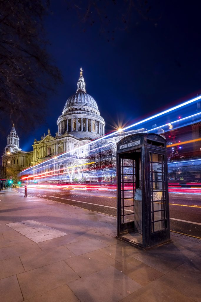 Night shot of a telephone buffet in front of the Cathedral St. Paul in London with sprints of light.