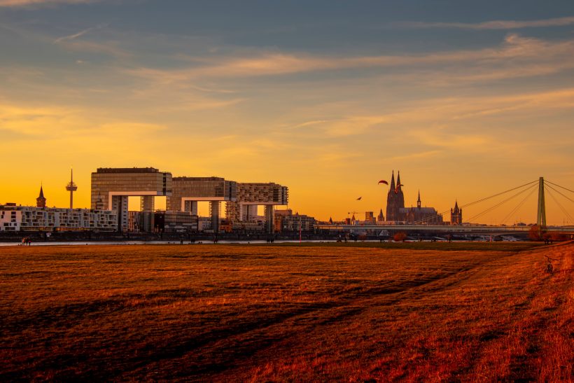 City landscape at sunset with modern buildings and church dome.