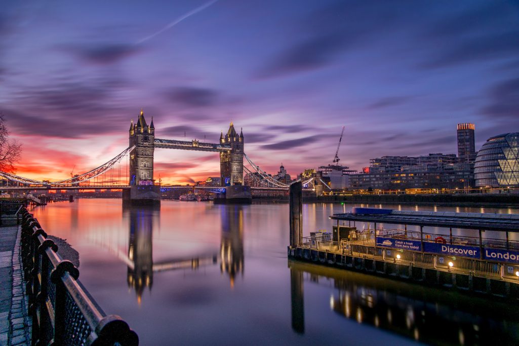 Die Tower Bridge und der Fluss Thames bei Sonnenaufgang, stimmungsvolle Farben reflektiert.