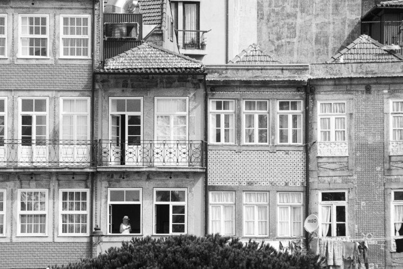 Town houses with windows in black and white, some windows open.