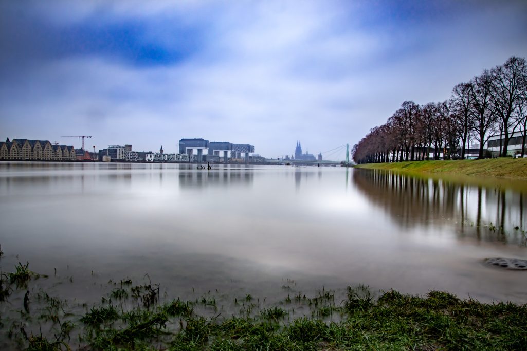 Ruhrgebiet Landschaft mit spiegelndem Wasser und bewölktem Himmel.