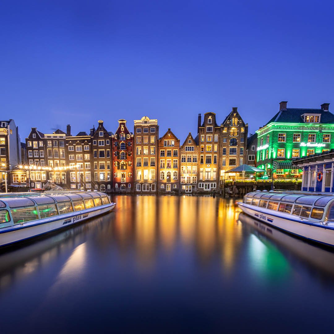 Colorful houses along a quiet canal at dusk.