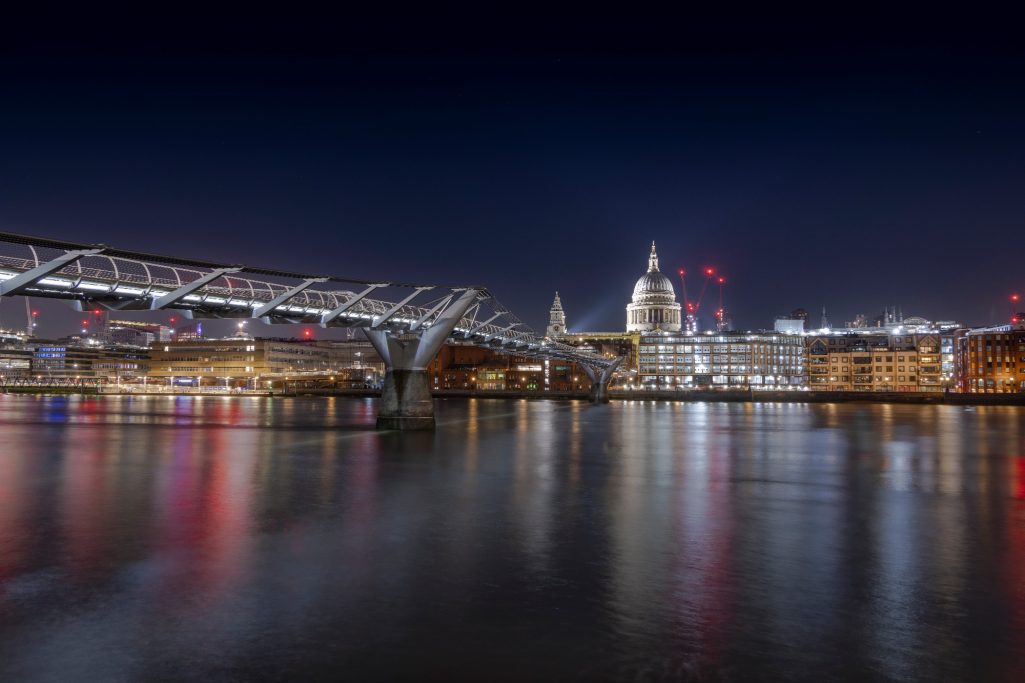 Nachtansicht der Themse mit der Millennium Bridge und der St. Paul's Cathedral im Hintergrund.