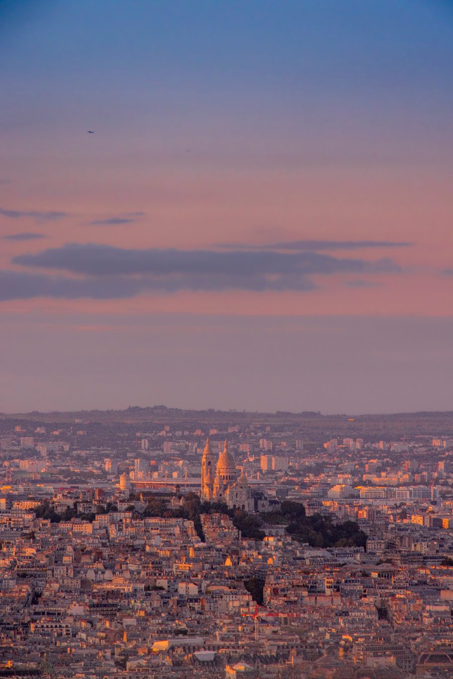 Pariser Skyline bei Dämmerung mit sanften Farben und silhouette von Gebäuden im Hintergrund.