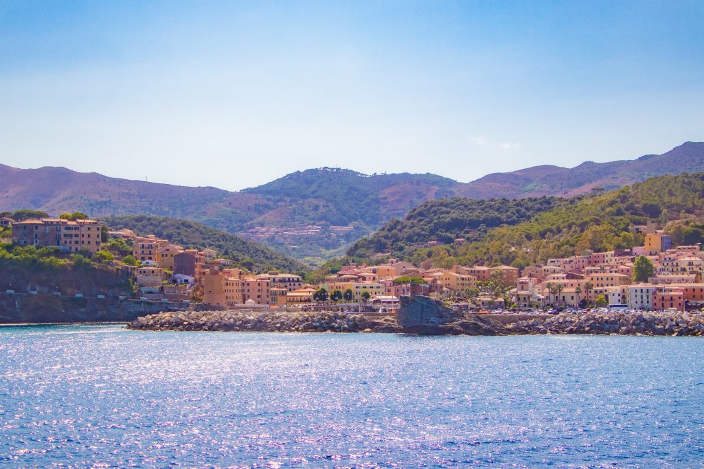 View of a coastal landscape with mountains and calm water.