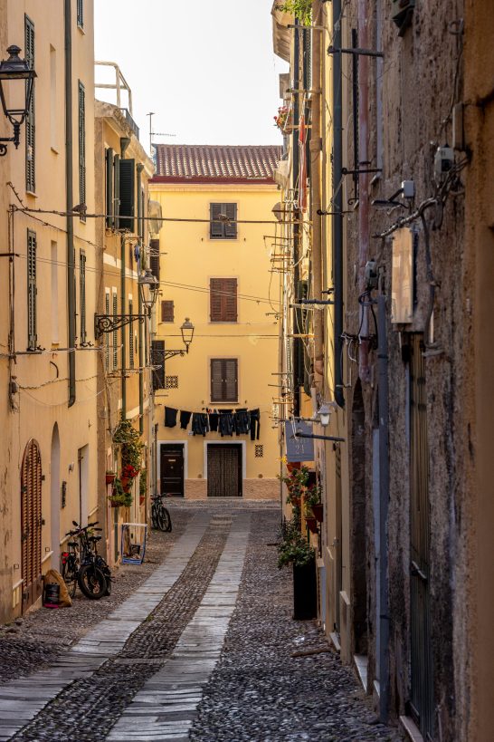 Enggasse mit gelben Gebäuden und schmalem Weg in einer historischen Stadt.