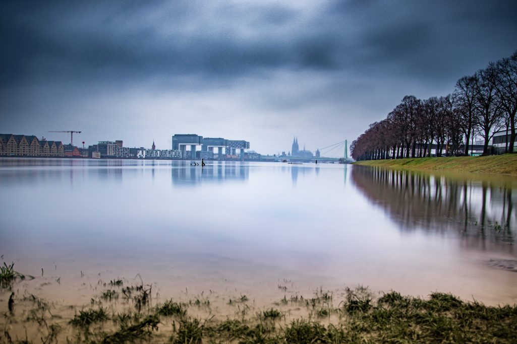 Ruhevolle Landschaft mit spiegelndem Wasser und bewölktem Himmel.