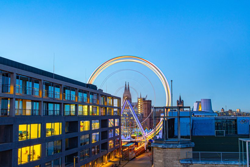 City view with a rainbow bike and modern buildings in the evening light.