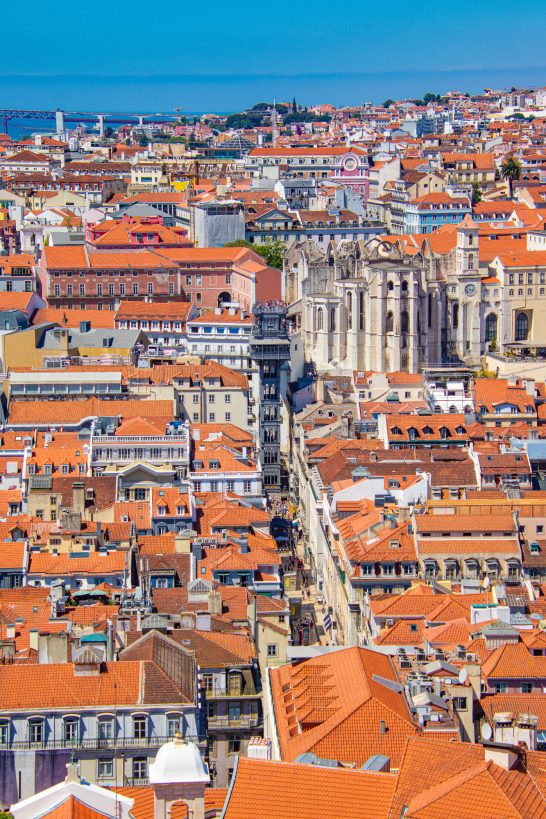 Überblick auf Lissabon mit roten Dächern, engen Straßen und Küstenansicht.