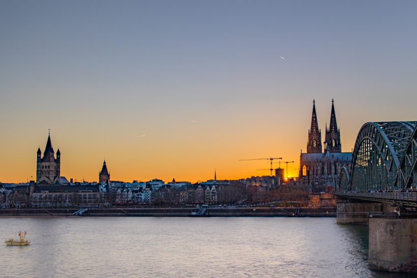 Kölner Skyline mit der Hohenzollernbrücke und dem Dom bei Sonnenuntergang.