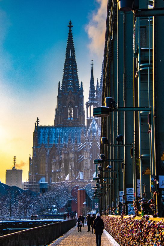 Cologne Cathedral with its imposing tower in front of a colourful sunset.