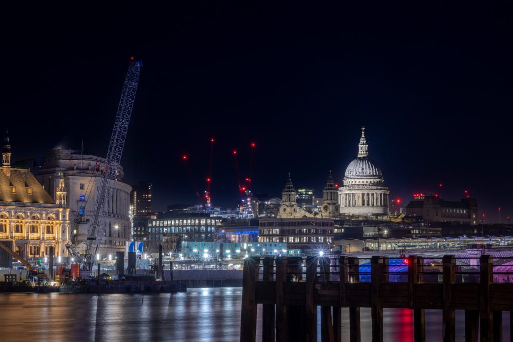 Nachtansicht auf London mit St. Paul's Cathedral und beleuchteten Gebäuden.