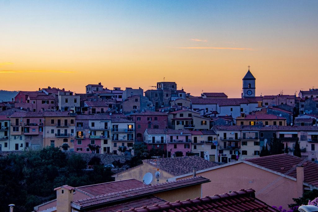 View of a city with colorful houses at sunset.